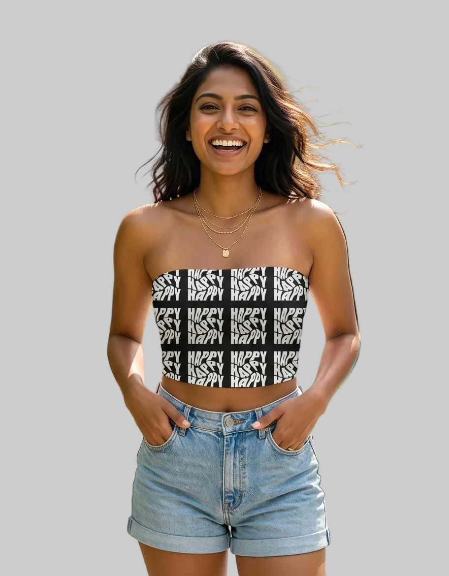 Woman wearing a black and white patterned top and denim shorts standing by a pool with greenery in the background.
