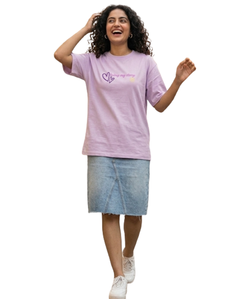Woman wearing a light purple t-shirt with a logo and text, standing on a white background